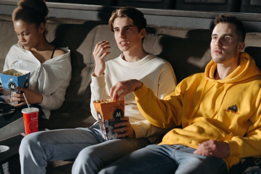 friends watching a movie eating pop corn